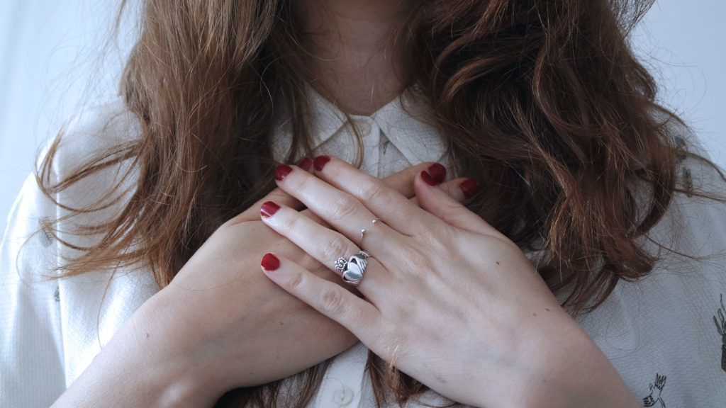 A woman holding her hands across her chest